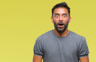 Yetişkin İspanyol adam korkuyor ve şok sürpriz ifade ile izole arka plan üzerinde korku ve yüz heyecanlı.