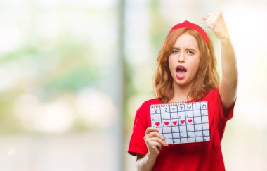 Genç güzel kadın Hayız tutan izole arka plan yüzünden takvim ile öfke, çılgın ve yükseltilmiş eliyle diye bağıran rahatsız ve hayal kırıklığına uğramış öfke kavramı bağırarak