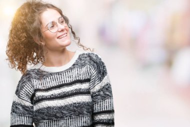 Güzel esmer kıvırcık saçlı Genç kız üzerinde gözlük takan arka plan uzak tarafına gülümseme ile yüzünde, doğal ifade arıyorum izole. Kendine güvenen gülüyor.