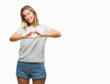Genç güzel kadın kalp simgesi ve elleriyle şekil gösterilen aşık gülümseyen izole arka plan yüzünden. Romantik kavramı.
