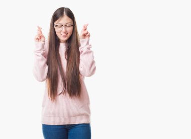 Gözlüklü geçiş parmakları umut ve gözleri kapalı ile gülümseyen izole arka plan üzerinde Genç Çinli kadın. Şans ve batıl kavramı.