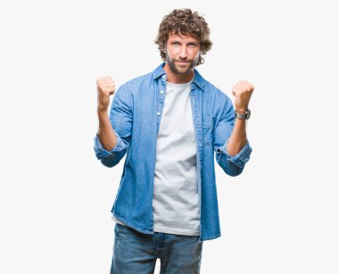 İzole arka plan kutlama üzerinden yakışıklı İspanyol modeli adam şaşırttı ve başarı için kaldırdı kollarını açarak hayret ve gözleri açık. Kazanan kavramı.