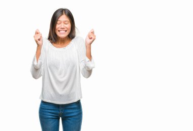 Genç Asyalı kadın izole arka kolları olan başarı için heyecan üzerinde zafer kutluyor gülümseyen kaldırdı. Kazanan kavramı.