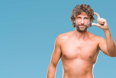 Yakışıklı İspanyol modeli adam seksi ve gömleksiz izole arka plan gülümseyen ve boyutu işaret parmaklı ararken ve kamera işi el ile kendinden emin eller üzerinde. Ölçü kavramı.