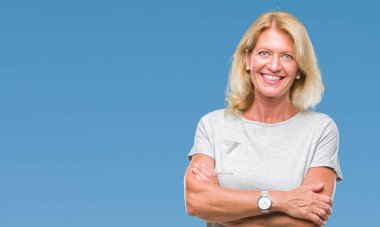 Orta yaş sarışın kadın izole arka plan mutlu yüz çapraz silah kameraya bakarak ile gülümseyen yüzünden. Olumlu bir kişi.