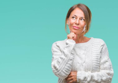 Üzerinde kış kazak giyen orta yaş üst düzey İspanyol kadın arka plan çene düşünme hakkında soru, dalgın ifade üzerine el ile izole. Düşünceli yüzüyle gülümsüyor. Şüphe kavramı.