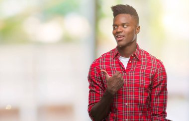 Genç Afro-Amerikan adam arıyor ve başparmak yanında yukarıyı mutlu yüz ile gülümseyen izole arka plan üzerinde.