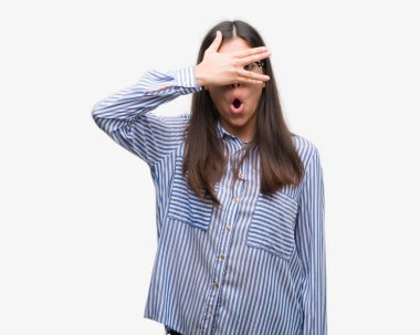 Yüz ve gözler el ile kapsayan şok bakmak genç güzel İspanyol iş kadın mahcup ifadeyle parmaklarımın arasından arıyor.