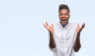 Afrikalı-Amerikalı genç deli kutluyor ve silah ile başarı için heyecanlı çığlık kaldırdı ve açık gözleri hayret izole arka plan üzerinde. Kazanan kavramı