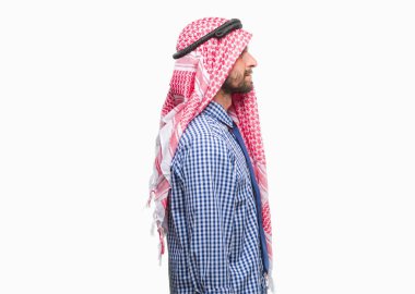 Genç yakışıklı Arap iş adamı giyen keffiyeh izole arka tarafına, seyir üzerinde dinlenmek doğal yüz emin gülümseme ile pozuyla profili.