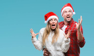 Üzerinde Noel şapka aşık genç çift arka plan çılgın ve kızgın bağırarak ve agresif ifade ve silah kaldırdı bağırmaya izole. Hayal kırıklığı kavramı.
