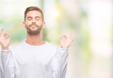 Yakışıklı delikanlı izole arka plan üzerinde dinlenmek ve gülümseyen gözlerle parmak ile meditasyon jest yapıyor kapalı. Yoga kavramı.