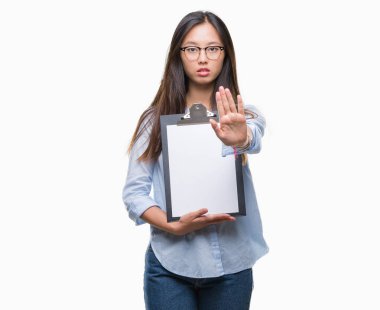 Genç Asya iş kadın holding Pano açık eliyle dur işareti ile ciddi ve kendine güvenen ifade, savunma jest yapıyor izole arka plan üzerinde