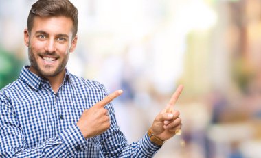 Yakışıklı delikanlı gülümseyen ve iki elleri ve parmakları ile tarafına işaret kamera bakarak izole arka plan üzerinde.