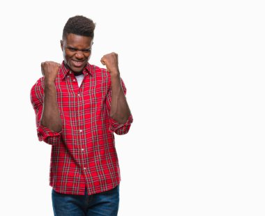 Gülümseyen ve başarı için çığlık genç Afro-Amerikan adam izole arka plan çok mutlu ve heyecanlı kaldırdı, silah ile kazanan jest yapıyor. Kutlama kavramı.