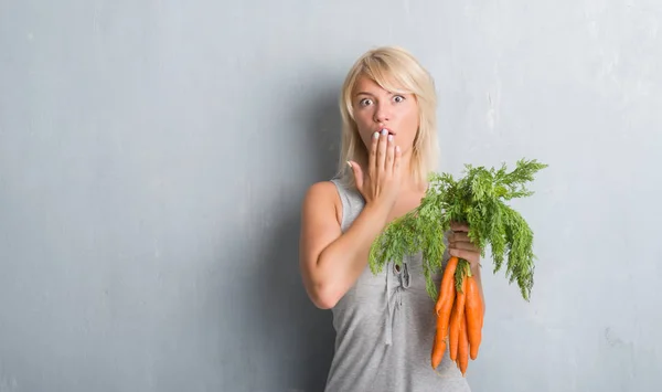 Kaukasiska Vuxen Kvinna Över Grå Grunge Väggen Håller Färska Morötter — Stockfoto