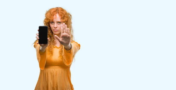 Νέοι Κοκκινομάλλα Γυναίκα Δείχνει Smartphone Ανοιχτό Χέρι Κάνει Στοπ Σοβαρές — Φωτογραφία Αρχείου