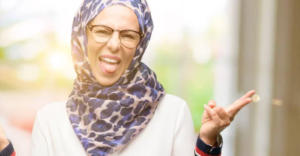 中世纪穆斯林阿拉伯妇女戴头巾看着相机显示佟和取得胜利标志用手指 — 图库照片