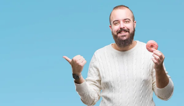 Young Caucasian Hipster Man Eating Sweet Donut Isolated Background Pointing — Stock Photo, Image