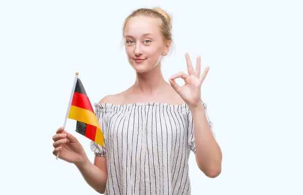 優秀なシンボルの指で サインをしているドイツの国旗を保持している金髪 代女性 — ストック写真