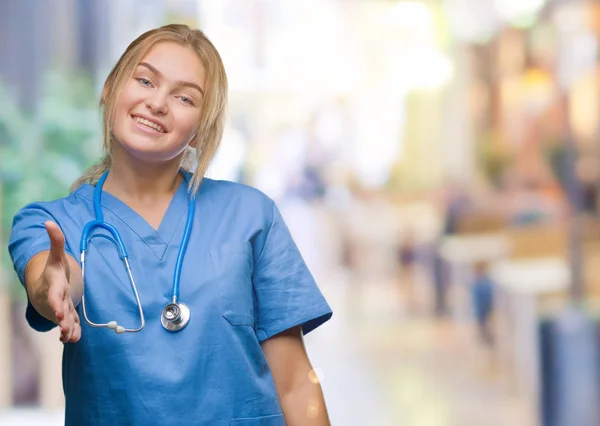 若い白人医師女性の外科医の制服を着ては 挨拶と歓迎フレンドリーな提供ハンドシェイクを笑顔の背景を分離しました ビジネスの成功 — ストック写真