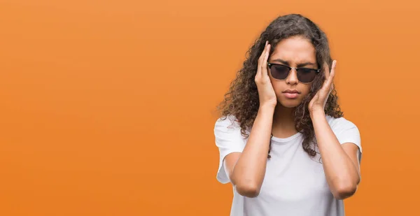 年轻的西班牙裔妇女戴着太阳镜 手放在头上 因压力而头部疼痛 患偏头痛 — 图库照片