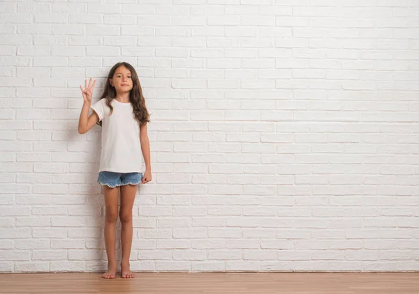 Junge Hispanische Kind Stakst Über Weiße Backsteinmauer Zeigt Und Zeigt — Stockfoto