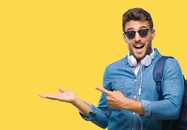 Junger Gutaussehender Touristenmann Mit Kopfhörer Und Rucksack Über Isoliertem Hintergrund — Stockfoto