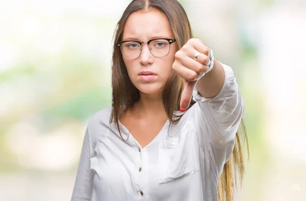 年轻的高加索美丽的女商人戴着眼镜在孤立的背景看起来不高兴和愤怒 显示拒绝和负面的大拇指向下的姿态 错误的表达 — 图库照片