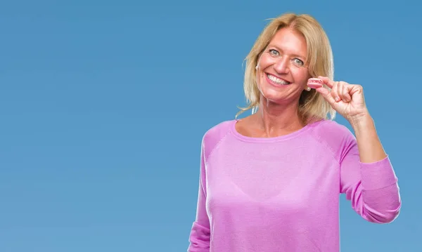 Mujer Rubia Mediana Edad Comiendo Galleta Macaron Rosa Sobre Fondo — Foto de Stock