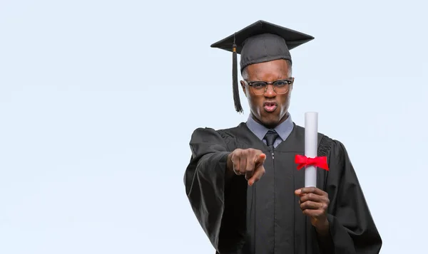 若いカメラと指で指している孤立の背景上の学位を保持するアフリカ系アメリカ人を卒業し 手に署名 正面からポジティブで自信のジェスチャー — ストック写真