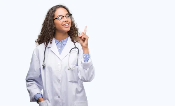 若いヒスパニック系アイデアに驚く女性を医者や幸せそうな顔 ナンバーワンと人差し指の質問 — ストック写真