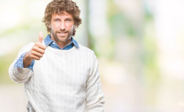 İspanyol yakışıklı hareketi el ile mutlu yaşasın yapıyor izole arka plan üzerinde giyen kış kazak modeli. Kameraya bakarak başarı gösteren ile ifade onaylama.