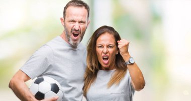 Orta yaş İspanyol çift izole arka rahatsız üzerinden futbol futbol topu ve öfke ile sinirli bağırarak holding, deli ve ile bağırmaya elini, öfke kavramı kaldırdı