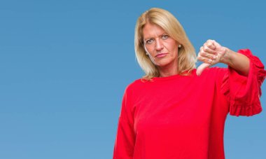 Orta yaş sarışın kadın yüzünden mutsuz ve kızgın ret gösterilen ve başparmak aşağı hareketi ile negatif seyir izole arka plan. Kötü ifade.