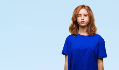 Komik surat ile yanakları şişirme izole arka plan üzerinde genç güzel kadın. Ağız ile hava, deli ifade şişirilmiş.