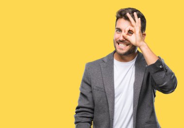 Genç yakışıklı iş adamı gülümseyen, parmakları ile mutlu yüz üzerinden seyir göz el ile ok jest yapıyor izole arka plan üzerinde.