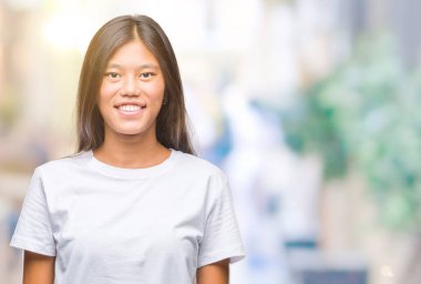 Genç Asyalı kadın yüzünde mutlu ve güzel bir gülümseme ile izole arka plan üzerinde. Şanslı kişi.