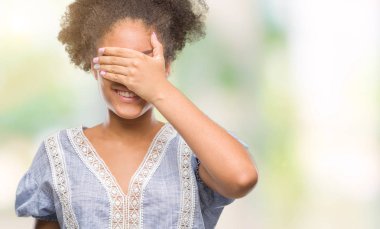 Genç afro Amerikan kadın gülümsüyor ve gözleri için sürpriz kapsayan yüz el ile gülüyor izole arka plan yüzünden. Kör kavramı.