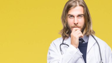 Genç yakışıklı Doktor emin çapraz kollar ve çeneme kaldırdı el ile gülümseme ile kameraya bakarak izole arka plan üzerinde uzun saçlı adam. Pozitif düşünce.