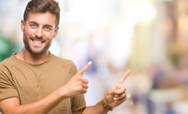 Yakışıklı delikanlı gülümseyen ve iki elleri ve parmakları ile tarafına işaret kamera bakarak izole arka plan üzerinde.