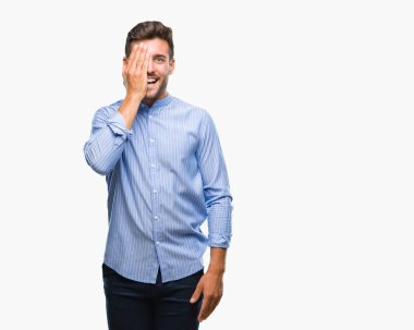 El yüz ve sürpriz duygu kendinden emin gülümseme ile tek gözüyle kapsayan izole arka plan üzerinde genç yakışıklı adam.