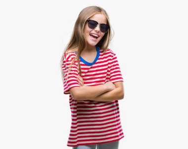 Genç güzel kız üzerinde güneş gözlüğü takıyor mutlu yüz ile gülümseyerek kameraya seyir silah geçti arka plan izole. Olumlu bir kişi.