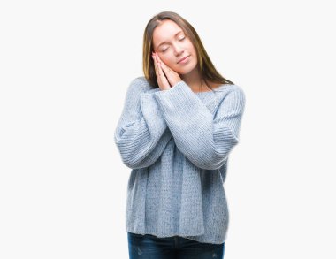 Uyku yorgun hayal ve ellerle birlikte poz ile kapalı gözler gülümseyen izole arka plan üzerinde kış kazak giyen genç güzel beyaz kadın.