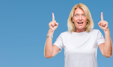 Orta yaş sarışın kadın izole arka plan üzerinden hayran ve yukarıya bakıp parmakları ile işaret şaşırttı ve silah kaldırdı.