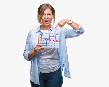 Adet takvim sürpriz yüz işaret parmağı kendini izole arka plan üzerinde tutan orta yaş üst düzey İspanyol kadın