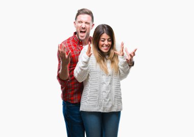 Deli aşık izole arka plan üzerinde kutluyor kış kazak giyen genç çift ve crazy arms ile başarı için kaldırdı ve heyecanlı çığlık gözler kapalı. Kazanan kavramı