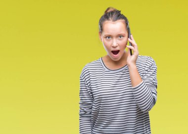 Genç güzel beyaz kadın Smartphone'da izole arka plan üzerinde bir sürpriz yüz, korkuyor ve heyecanlı korku ifadesi ile şok korkmuş söz