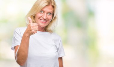 Orta yaş sarışın kadın hareketi el ile mutlu yaşasın yapıyor izole arka plan yüzünden. Kameraya bakarak başarı gösteren ile ifade onaylama.