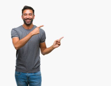 Gülümseyen ve iki elleri ve parmakları ile tarafına işaret kamera bakarak izole arka plan yetişkin İspanyol adam.